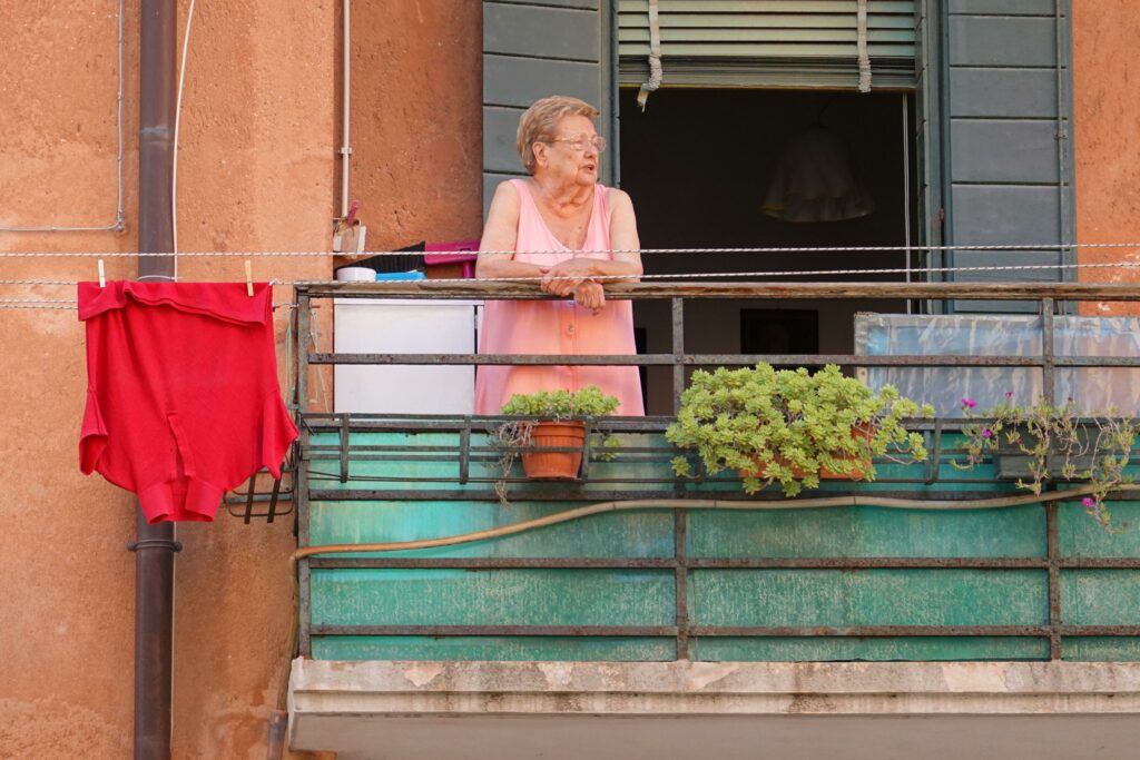 Ältere Dame auf Balkon stehend